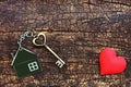 Home key with love house keyring decorate with mini heart on wood background, sweet home concept Royalty Free Stock Photo