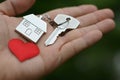 Home key with love house keyring and red mini heart on hand, sweet home giving, concept Royalty Free Stock Photo