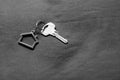 Home key with house keyring on bed in black and white, property concept, copy space