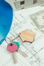 Home keys, currencies dollar, electrical construction diagrams and small house under contruction. Building or buying home Royalty Free Stock Photo