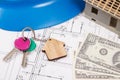 Home keys, currencies dollar, electrical construction diagrams and small house under contruction. Building or buying home Royalty Free Stock Photo