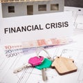 Home keys, euro and inscription financial crisis on housing plan. House under contruction. Crisis of real estate market. Reduced