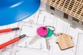 Home keys, electrical construction diagrams and small house under contruction. Building or buying home Royalty Free Stock Photo