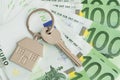 Home keys and a small house on currencies euro background Royalty Free Stock Photo