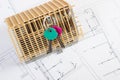 Home keys and small house under construction on electrical drawings, building home concept Royalty Free Stock Photo