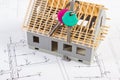 Home keys and small house under construction on electrical drawings, building home concept Royalty Free Stock Photo