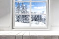 Home kitchen interior with a white wooden table and a place for an advertising product. Winter window view background.