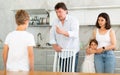 At home in kitchen, parents scold son for imprudent act committed