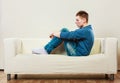 Young pensive man sitting on couch Royalty Free Stock Photo