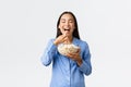 Home leisure, sleepover and slumber party concept. Smiling delighted asian girl enjoying eating favorite popcorn Royalty Free Stock Photo