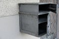 A home letterbox, mailbox or post-box with three compartments made of grey metal