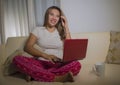 Home lifestyle portrait of young attractive and natural Asian Indonesian woman in pajamas pants relaxed on couch networking using Royalty Free Stock Photo