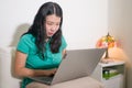 Home lifestyle portrait of young happy and beautiful Asian Japanese woman at home networking and studying using laptop computer on Royalty Free Stock Photo