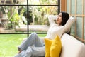 Home lifestyle woman relaxing on sofa in living room. Happy girl lying down on comfortable pillows Royalty Free Stock Photo