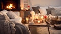 Home living room on a winter evening with cozy fireplace in style of Hygge. Soft blankets and cushions on the sofas Royalty Free Stock Photo