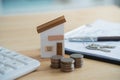 Home loan concept. House model on a table as a real estate agent and customer discuss contracts for buying, insuring, financing