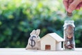 Home loan, mortgages, debt, savings money for home buying concept : Hand holding coin over glass jar. US dollar in a money bag, Royalty Free Stock Photo