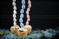 Mini cream cakes with blue Easter eggs in a tall vertical line for creative table decorations