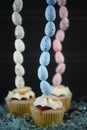 Mini cream cakes with blue Easter eggs in a tall vertical line for creative table decorations