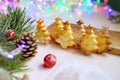 Home made bakery on christmas lights background. Baked fir trees. New year atmosphere. Holidays celebration. Food art. Royalty Free Stock Photo