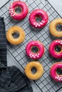 Home made baking - fresh baked donuts with bright pink icing on cooling rack Royalty Free Stock Photo