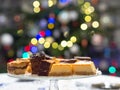 Home made cake on the plate. Bokeh christmas tree lights background