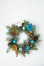 home made Christmas tree wreath made of fir branches on a light wooden background with blue and silver balls in the colors of 2021 Royalty Free Stock Photo