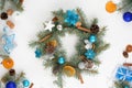 home made Christmas tree wreath made of fir branches on a light wooden background with blue and silver balls in the colors of 2021 Royalty Free Stock Photo