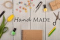 Home-made concept - text Hand made, flower tulip, note pad, sewing scissors, nail polish and buttons in the shape of hearts Royalty Free Stock Photo