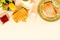 Top view of waffles and pomegranate grains arranged over white background. Royalty Free Stock Photo