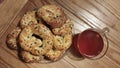 home-made fresh cottage cheese bagels with cheese and black and light sesame seeds on a plate and compote in a transparent cup