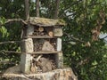 Home made insect hotel decorative bug house from sandstone and wood, ladybird and bee home for butterfly hibernation and Royalty Free Stock Photo