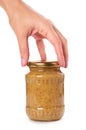 Home made mustard in glass bottle in hand isolated on white background Royalty Free Stock Photo