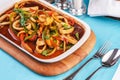 Home-made noodles stewed with green and red peppers, vegetables, squid rings, beef. Royalty Free Stock Photo