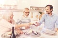 Positive aged parents enjoyign meal with their adult son