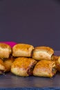 Home made sausage rolls on dark slate mat red napkin, portrait, copyspace, macro