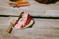 Home made strawberry sponge cake with fresh strawberries on a paper flate with a wooden spoon on the side