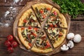 Home-made vegan pizza with tomatoes, bell peppers, mushrooms and fennel on an old wooden table. Top view