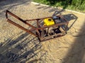 Home-made vibratory rammer stands on a site with newly laid granite paving stones. Do-it-yourself concept. Creation of gasoline