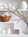 Home minimalist interior with Easter decor. Branches with budding buds in a glass vase on shelves in the shape of a Royalty Free Stock Photo