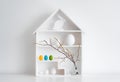Home minimalist interior with Easter decor. Branches with budding buds in a glass vase on shelves in the shape of a Royalty Free Stock Photo