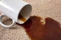 Home mishap, stained carpet, and domestic accident concept with close up of a spilled cup of coffee leaving a stain on the brown Royalty Free Stock Photo