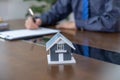 home model, Real estate agents hand use pen explains the business contract for signing a business contract, renting, buying,