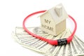 Home model and red padlock on dollar banknotes pile isolate on white background