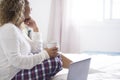 Home morning wake up and breakfast with woman sitting out the bed looking outside the window - laptop computer and people in Royalty Free Stock Photo