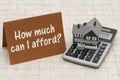 Home Mortgage Affordability, A gray house, brown card and calculator on stone background Royalty Free Stock Photo