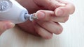 Home nail care. Woman doing herself a hardware manicure. Nail dust from polishing. Hands close up