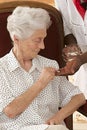 Home nurse giving elderly woman vitamin pills at home