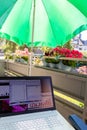 Home office on the balcony with headset and white laptop showing diagram chart and programs on screen on a table