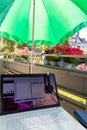 Home office on the balcony with headset and white laptop showing diagram chart and programs on screen on a table